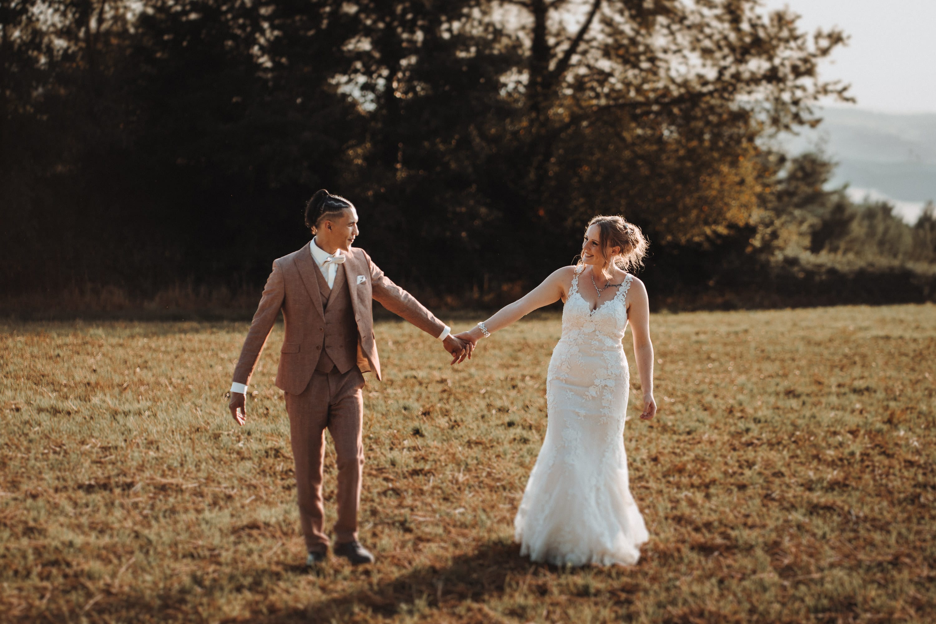 Das Paar Hand in Hand auf der sommerlichen Wiese